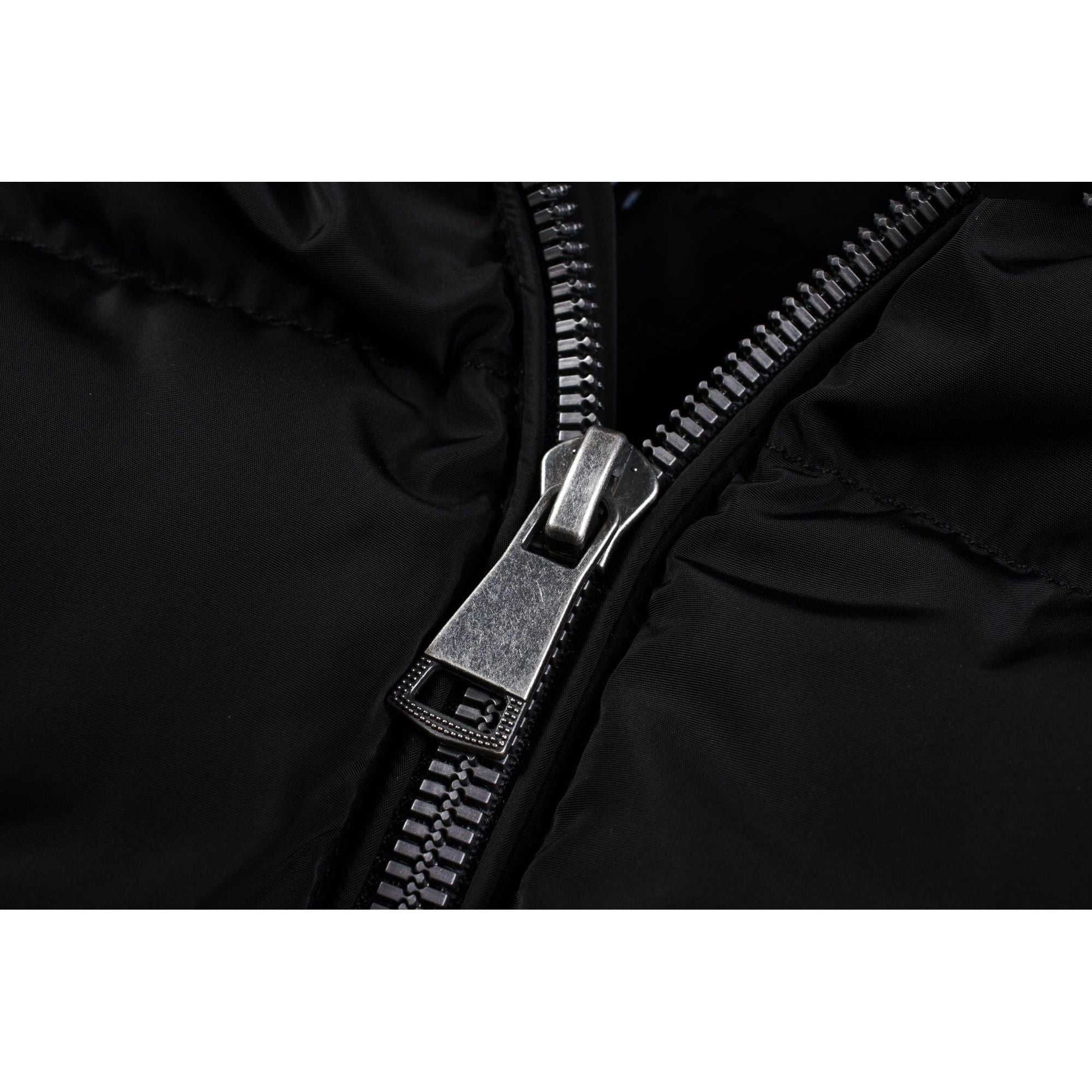 Close-up of zipper on black mid-length women's winter puffer coat with fleece lining.