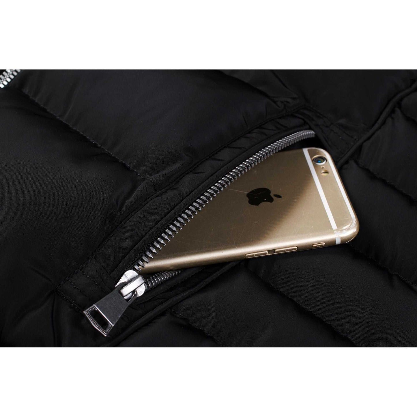 Close-up of a side zip pocket on a black mid-length women's winter coat with a phone inside.