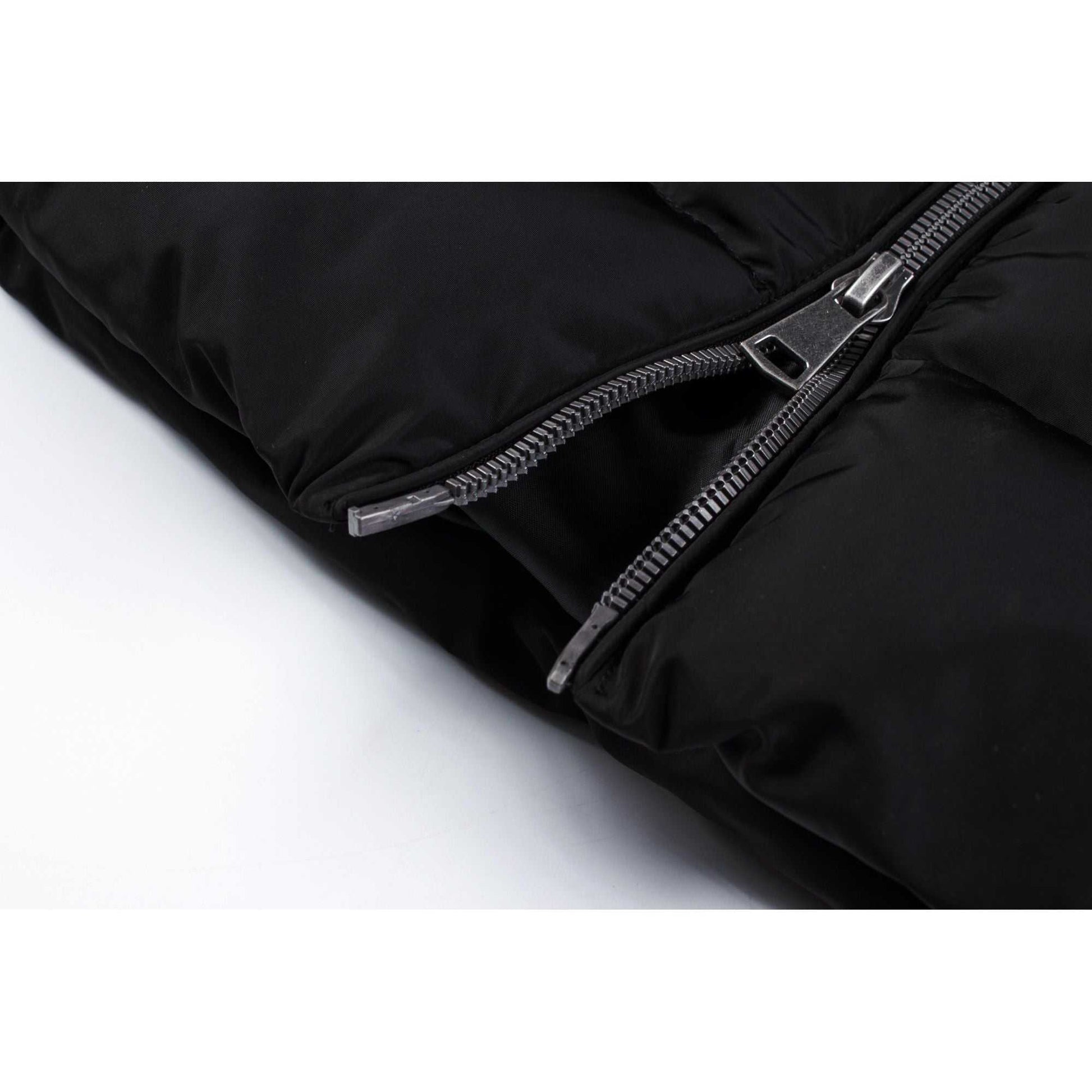 Close-up view of black quilted winter coat with zip closure.