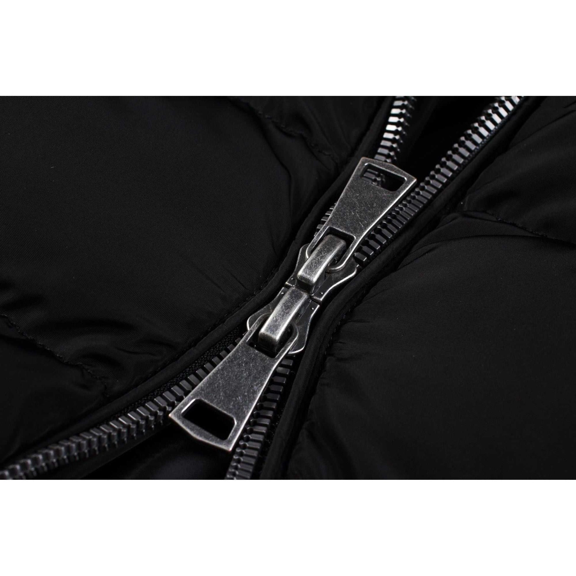 Close-up of zipper on black mid-length women's winter coat with fleece lining.